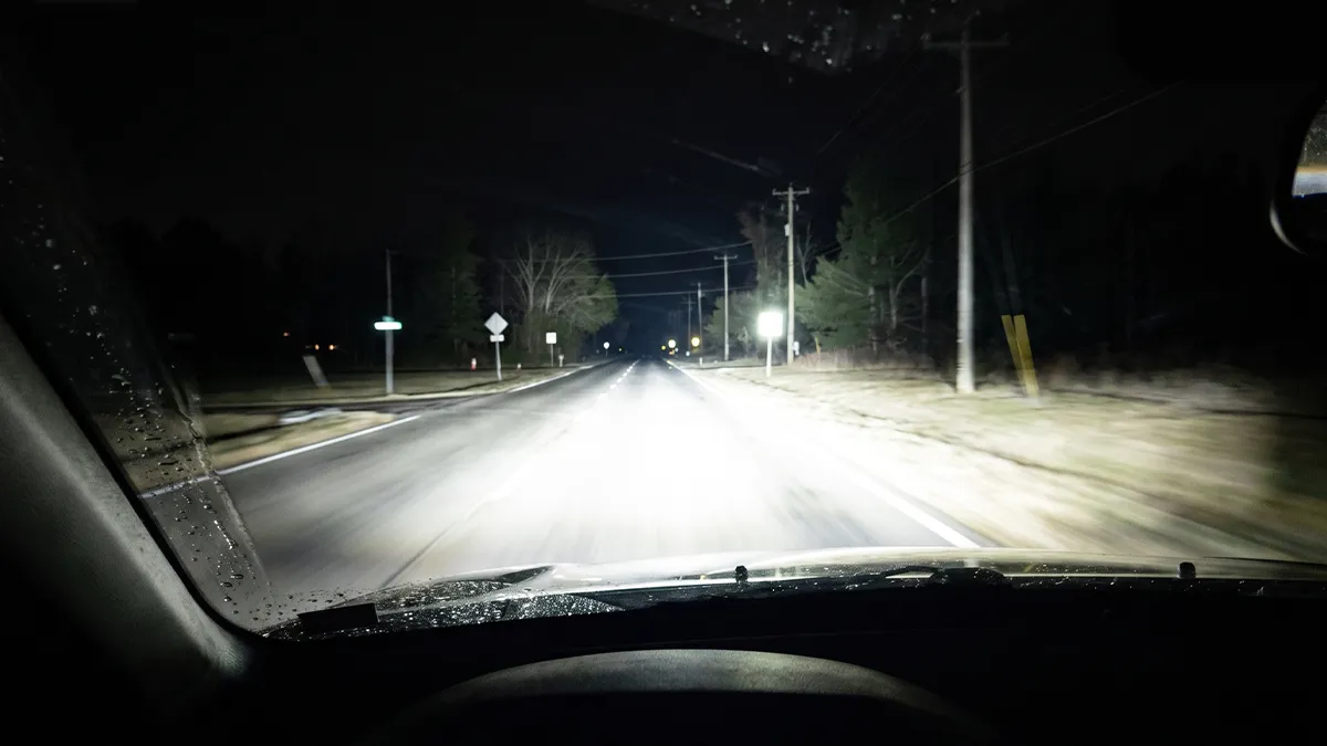ELERON bi-LED low beam pattern at night on a dark road — wide white beam with a sharp cutoff