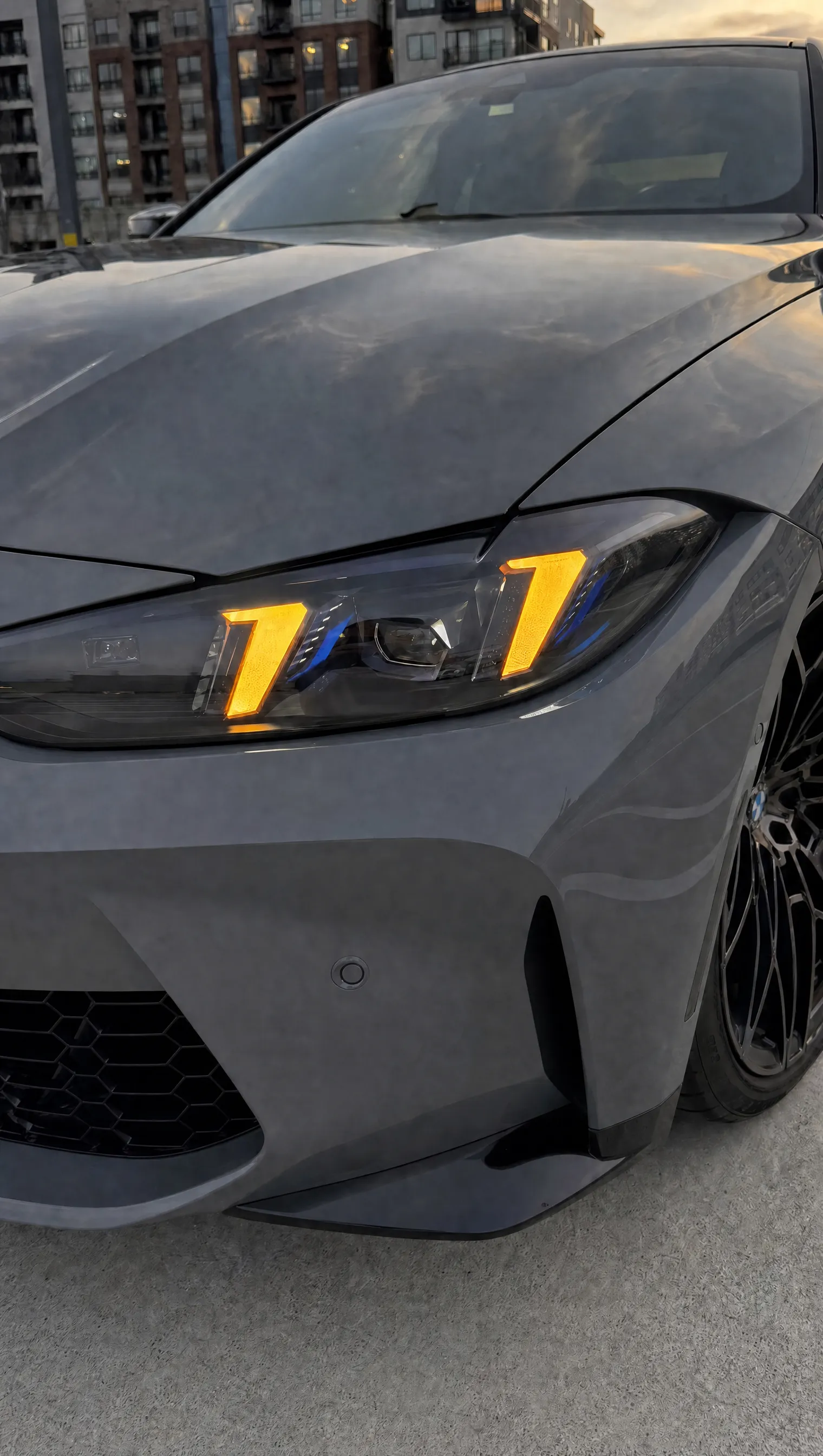 BMW G82 M4 arrow-DRL headlight close-up in amber DRL mode
