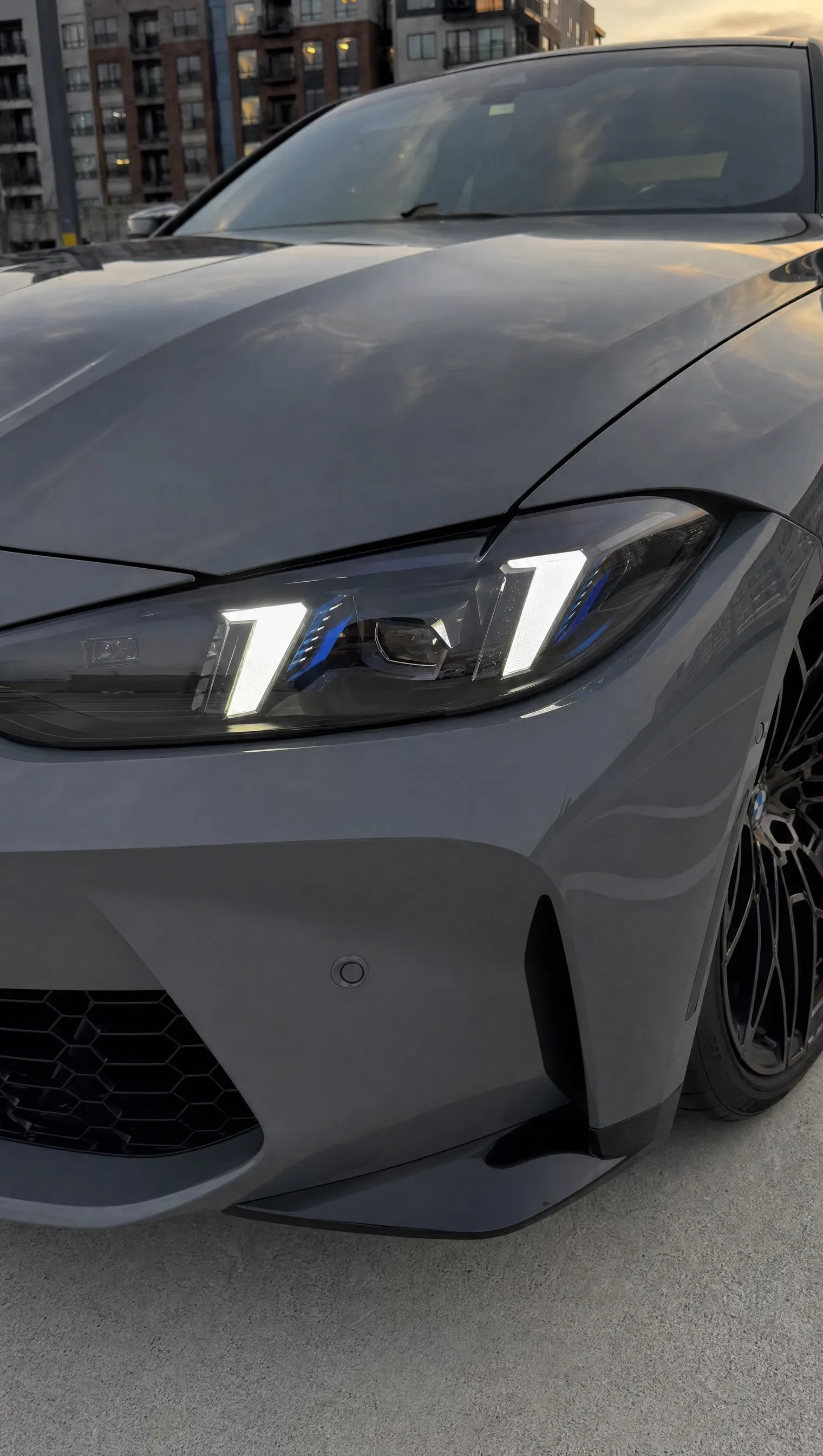BMW G82 M4 arrow-DRL headlight close-up in white DRL mode