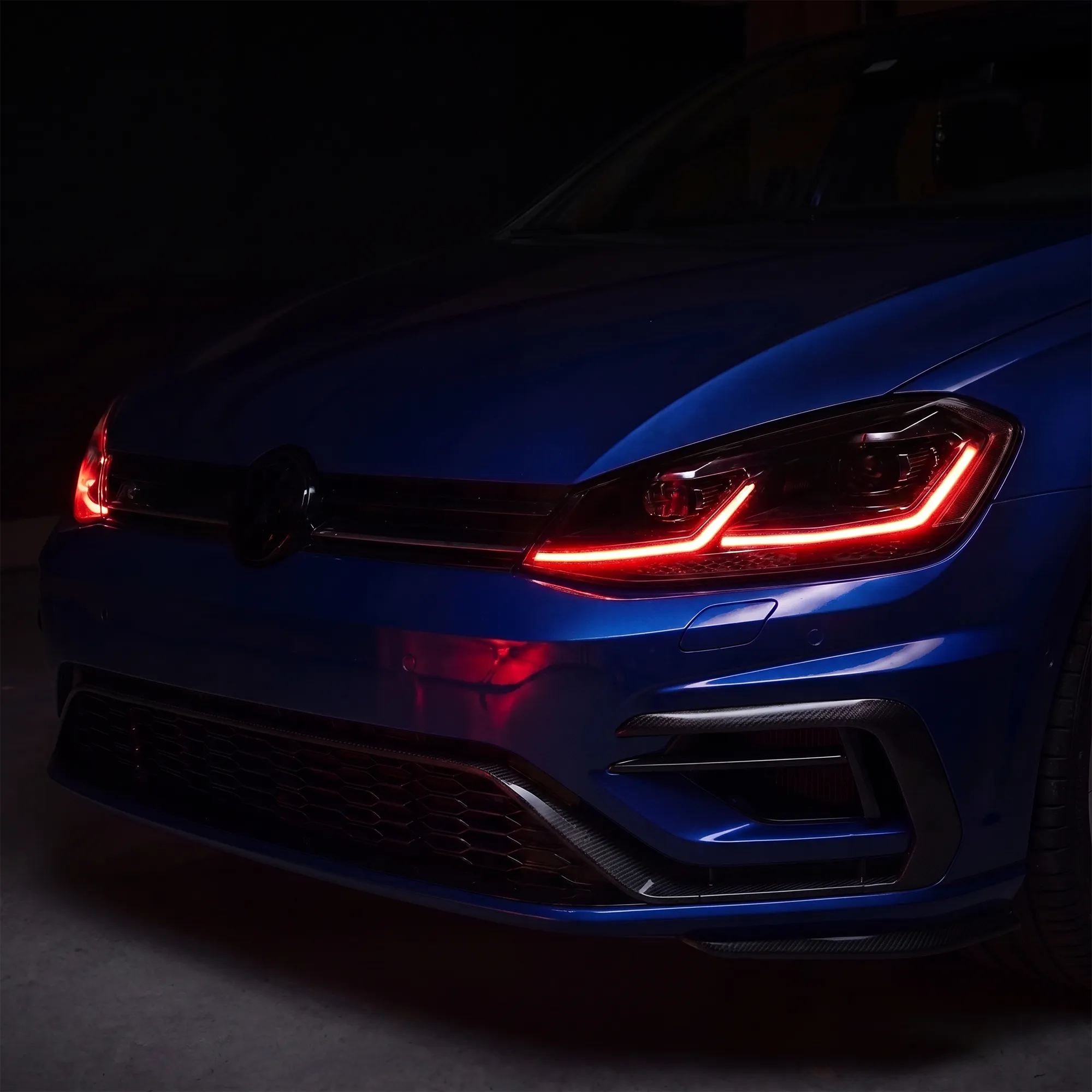 VW Golf Mk7.5 headlight with switchable red DRL — close-up of the dual-L signature in red